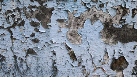 Stock Photo - The old flaky blue paint peels off the old cement plaster wall.の写真素材