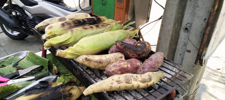 Corn,banana and sweet potato grilled traditional,sidewalk food vendors,street food stall,street vendor in Bangkok - Stock Photoの素材