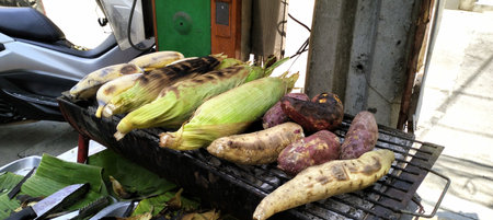 Corn,banana and sweet potato grilled traditional,sidewalk food vendors,street food stall,street vendor in Bangkok - Stock Photoの素材