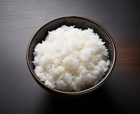 Hot white rice in a bowl on a wooden table, top view.Rice is the staple food of Asia.の素材