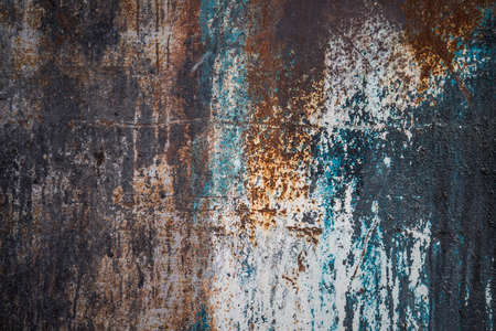 An abstract photograph, of a painted metal surface, stained in shades of blue,black and white. Areas of rusty metal are also present.の写真素材