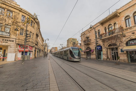Jerusalem, Israel - February 15, 2018: A tram passes in the nearly empty Jaffa street, early in the...