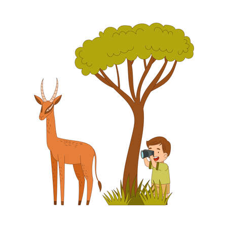 Little Boy Traveler Visiting Tropical National Park Sitting in Bush with Camera Taking Photo of Antelope Vector Illustrationのイラスト素材