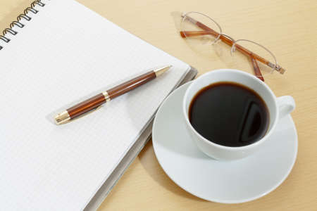 Image of notebook, coffee cup, pen and glassesの写真素材