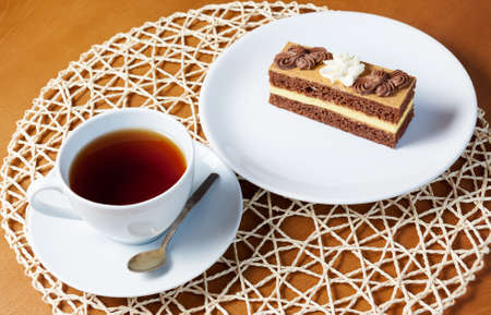Cup of tea and sweet cake on wooden tableの写真素材