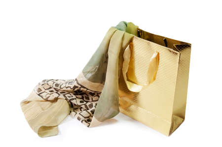 Gold gift bag and  green silk scarf isolated on whiteの写真素材