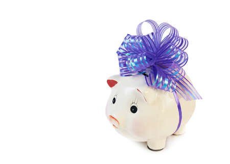 Piggy bank with big violet bow isolated on whiteの写真素材