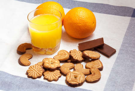 Orange juice, chocolate  and cookies on a tableの写真素材