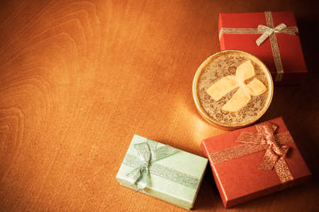 Colored gift boxes with decorative bows on wooden background. Vintage style. Selective focusの写真素材