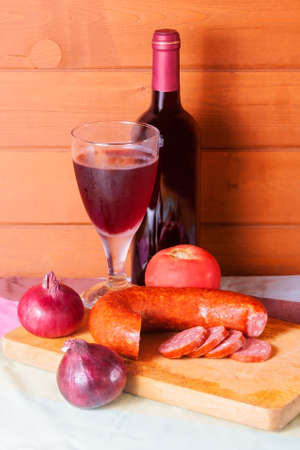 Wine in bottle and glass and sausage on wooden backgroundの写真素材