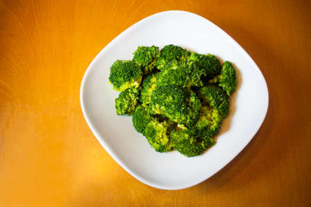 Boiled broccoli in white bowl on wooden tableの写真素材