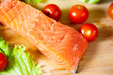Fresh salmon with tomatoes on a cutting board. Selective focusの写真素材