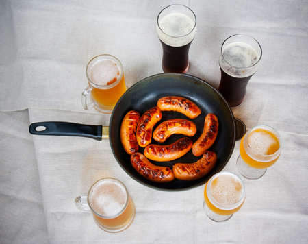 Grilled sausages and beer glasses  on table. Top viewの写真素材