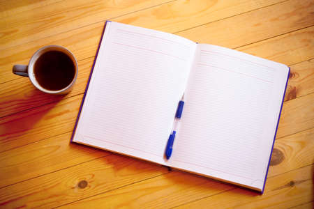 Cup of tea, pen, opened organizer on wooden backgroundの写真素材