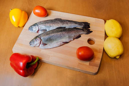 Fresh trouts on wooden cutting boardの写真素材