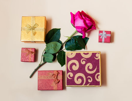 Gift boxes and rose flower on beige background