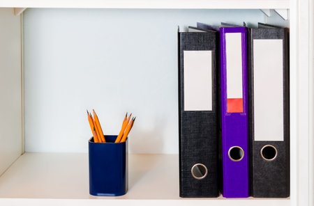 White  shelf with office folders and pencil holder