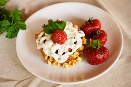 Waffles with whipped cream and strawberries. Selective focusの写真素材