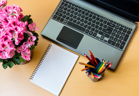 Blank notepad and laptop on office deskの写真素材