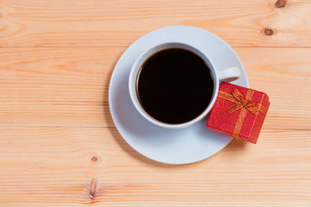 Cup of coffee and gift box on wooden backgroundの写真素材
