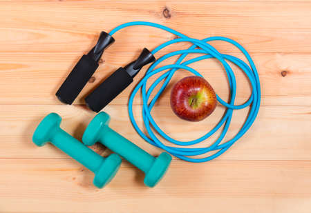 Dumbbells and skipping rope on wooden background. Top viewの写真素材