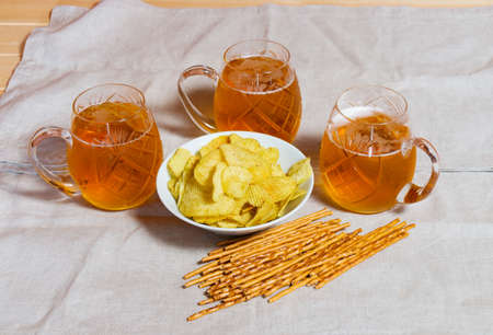 Three mugs of beer and potato chips on table. Selective focusの写真素材