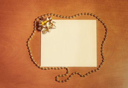 Note card with golden bow on wooden backgroundの写真素材