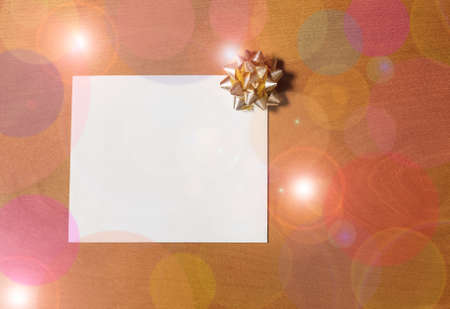 Note card with golden bow on wooden backgroundの写真素材