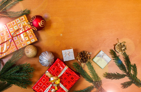 Christmas border made of fir branches, decorations and gifts. Flat lay, top view.