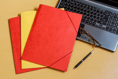 Folders and laptop on deskの写真素材