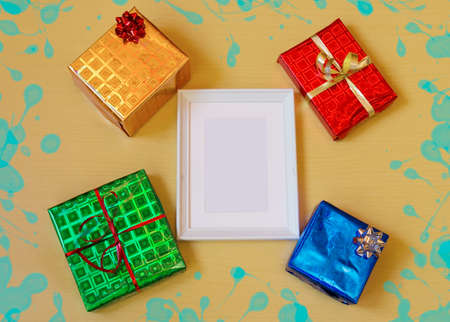 White photo frame and gifts on wooden backgroundの写真素材