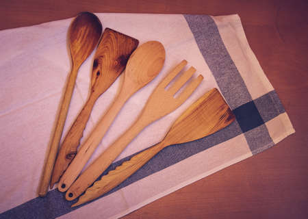Wooden kitchen utensils and kitchen towel on wooden tableの写真素材