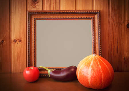 Fresh vegetables and picture frame on wooden backgroundの写真素材