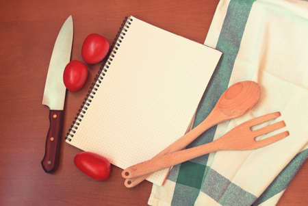 Kitchen utensils with empty notebook on wooden tableの写真素材