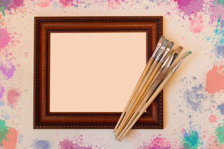 Frame with paint brushes on beige backgroundの写真素材