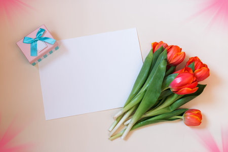 Tulips, card and gift box on beige background. Top view with copy space.の写真素材