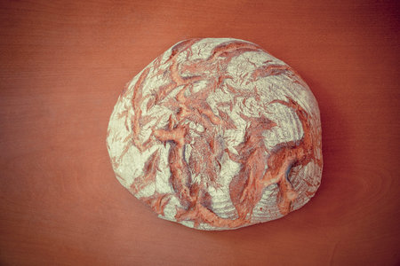 Traditional round rye bread on wooden background. Top view.