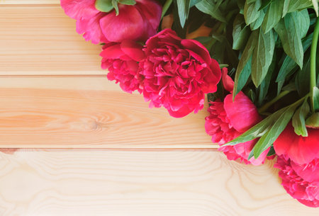 Red peonies on wooden background. Flat lay. Place for text.