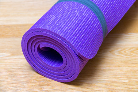 Yoga mat on wooden floor. Selective focus.