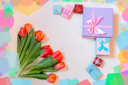 Tulip flowers and colorful gift boxes on pastel background. Top view with copy space.