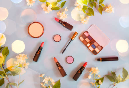 Set of makeup cosmetics and jasmine flowers on blue background. Top view.の写真素材