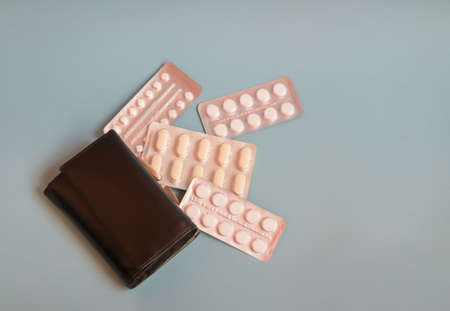 Pills falling out of the purse. Increased prices for medicines concept. Top view, copy spaceの写真素材
