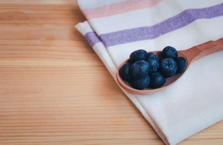 Bilberries on a wooden spoon.  Concept of healthy nutrition. View with copy space.の写真素材
