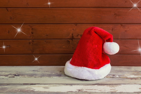 Fluffy Santa hat on aged wooden table. Christmas background. View with copy space.の写真素材