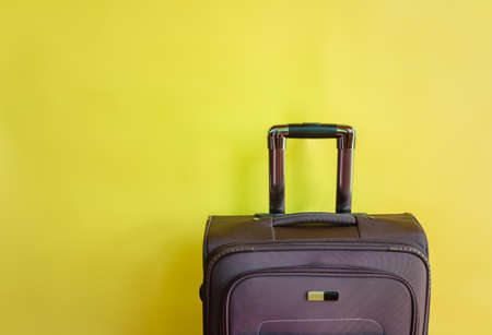 Brown suitcase on yellow background. View with copy space.の写真素材