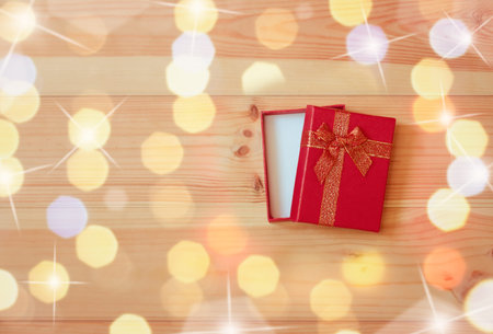 Opened red gift box on wooden background. Top view with copy space.