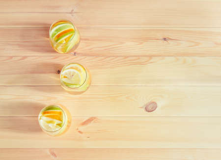 Glasses of white wine sangria with orange, green apple and lemon on wooden table.の写真素材