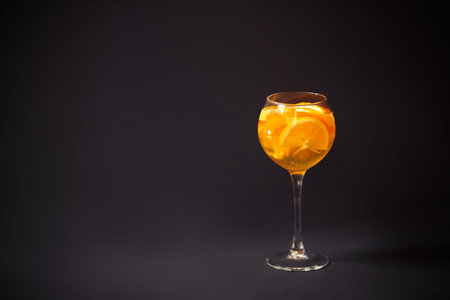 Glass of white wine sangria with orange and lemon  on dark background. View with copy space.の写真素材