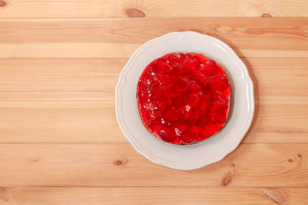 Strawberry cake on white plate on wooden table. Top view, copy space.の写真素材