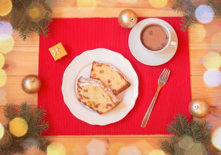 Christmas cake with candied fruits and raison, Ñup of homemade hot chocolate, christmas balls and fir branches on wooden table. Top view.の写真素材